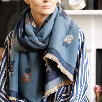 A woman wearing the Spy Cat Cashmere blend Scarf in a muted blue color, a great gift for cat lovers.